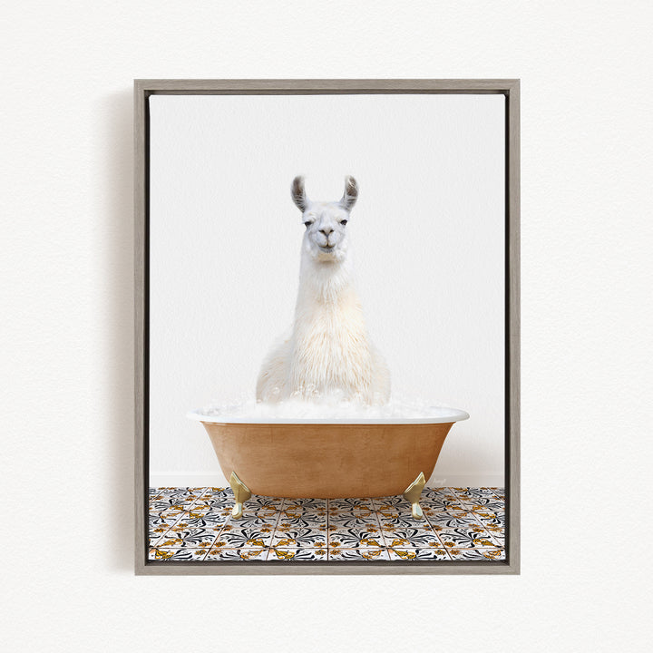 A white llama sitting in a bathtub filled with bubbles, with a patterned tile floor in the background.