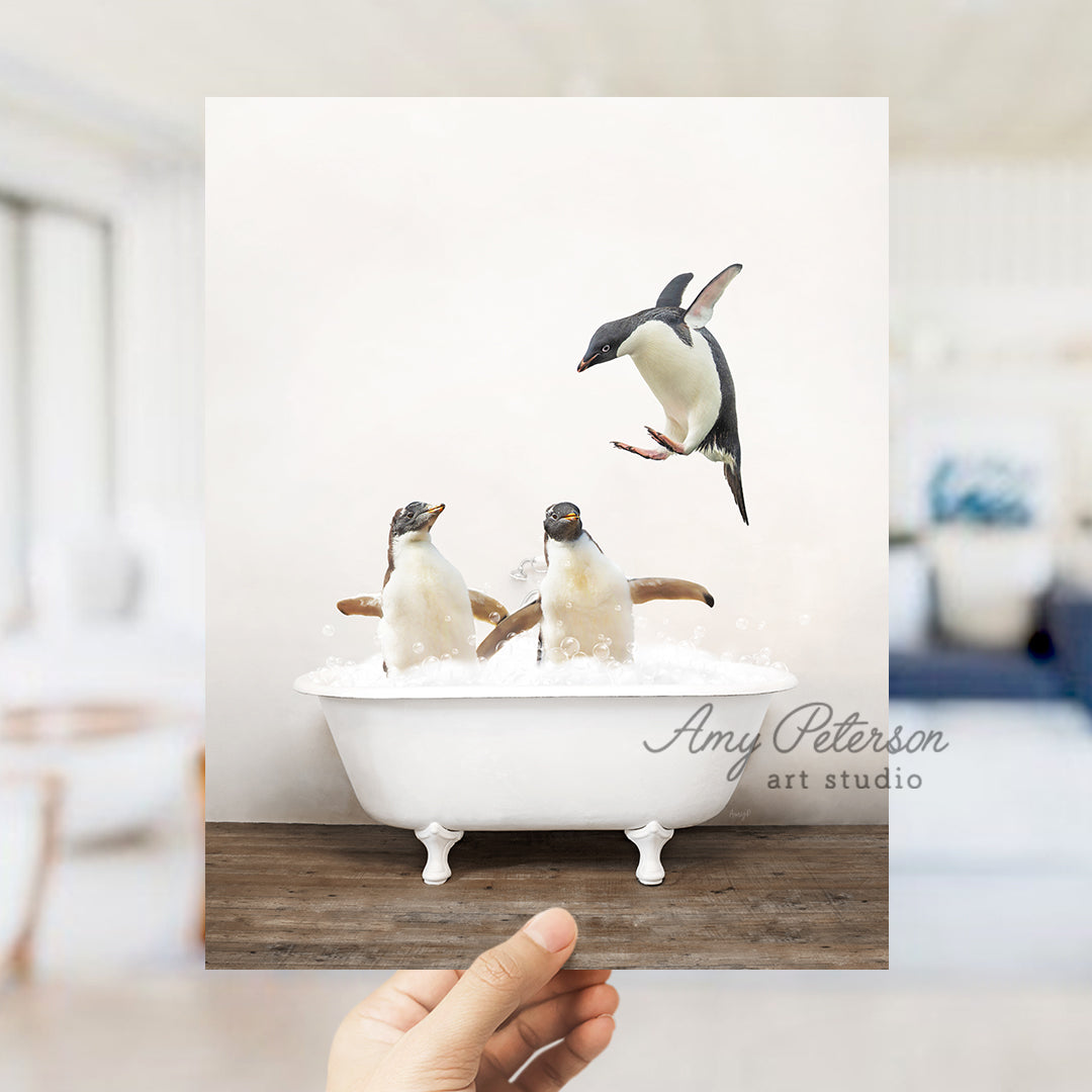 a hand holding up a card with penguins in a bathtub