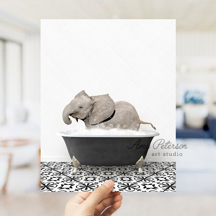 a person holding up a card with an elephant in a bathtub