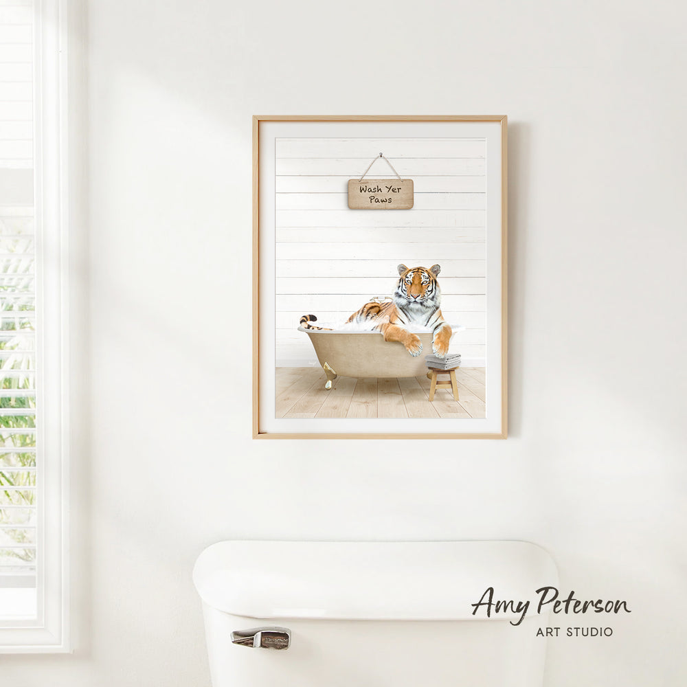 A framed print of a tiger sitting in a bathtub, with a sign above it that says "Wash Your Paws".