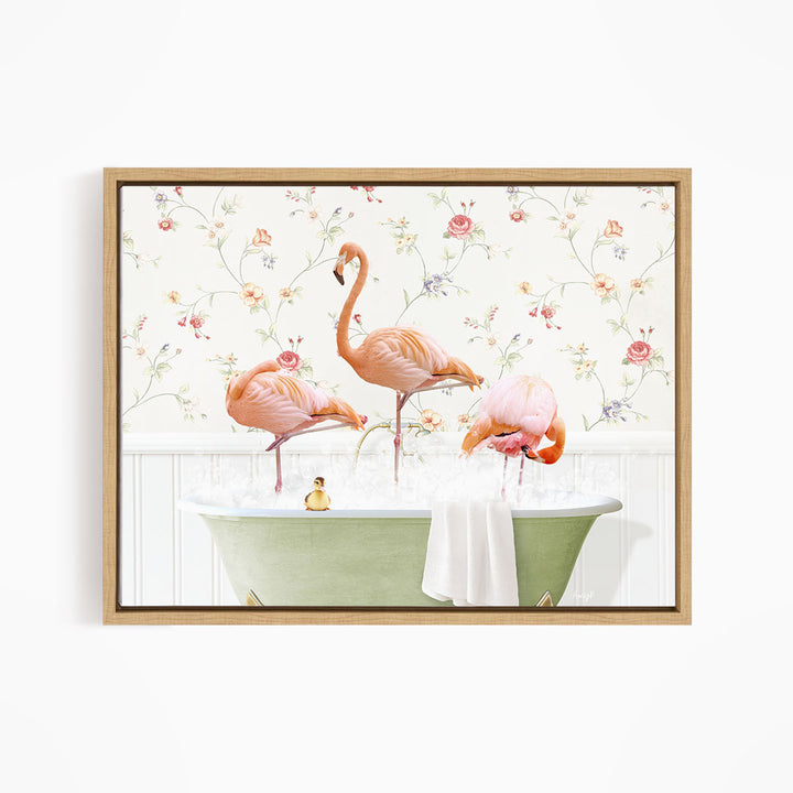 A framed print depicting three pink flamingos standing in a green bathtub, with a floral wallpaper in the background.
