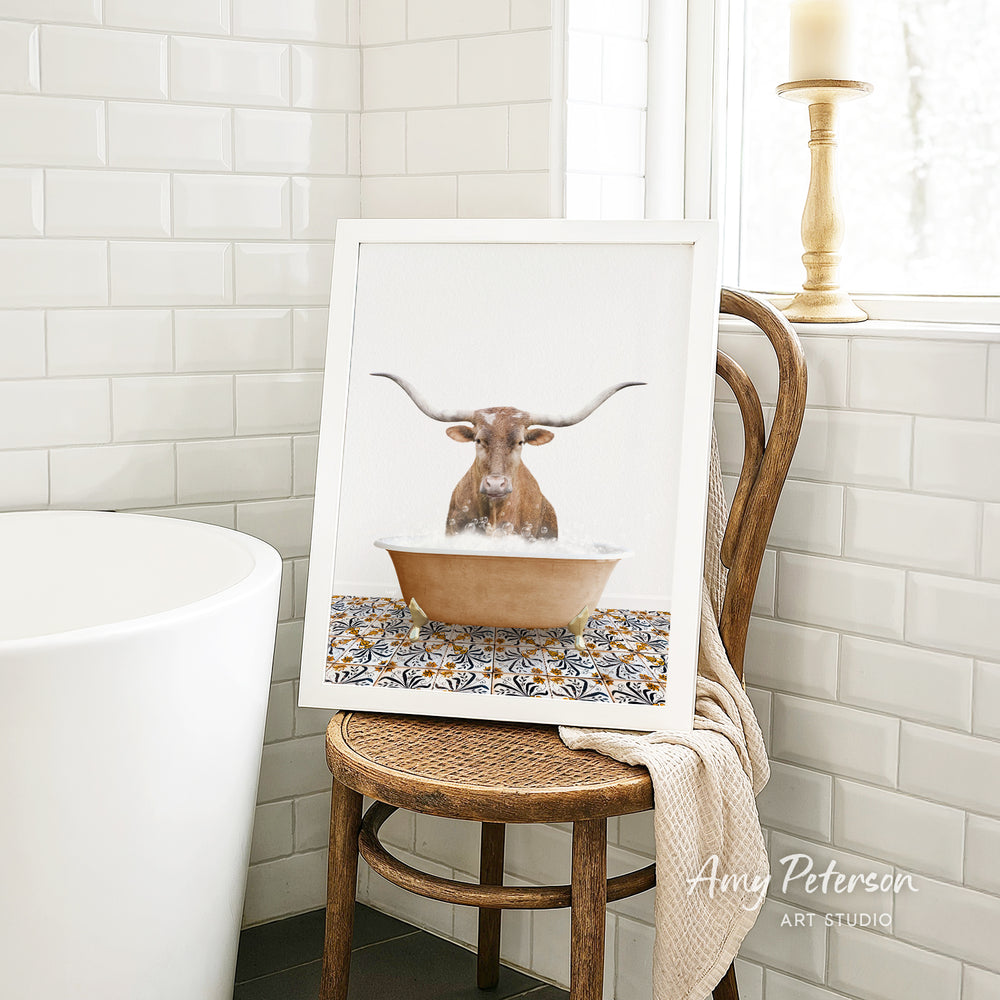 a framed picture of a bull with horns sitting in a bathtub, surrounded by a patterned tile design.
