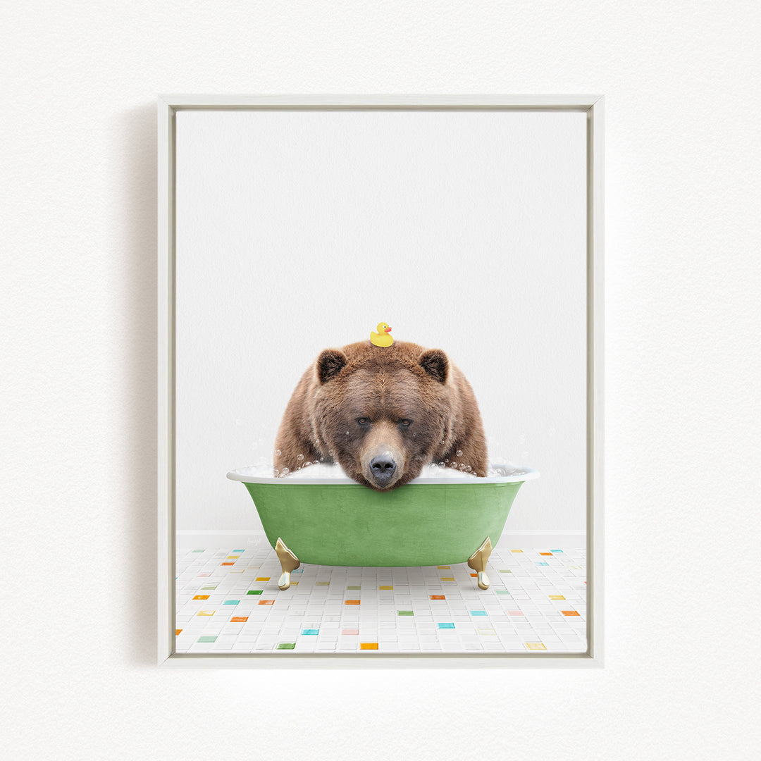 A brown bear is sitting in a green bathtub, with a yellow rubber duck perched on its head.