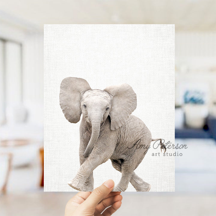 a hand holding up a picture of an elephant