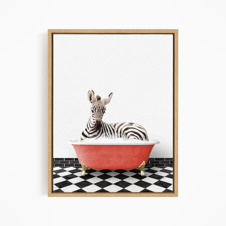 A zebra is sitting in a red bathtub on a black and white checkered floor.