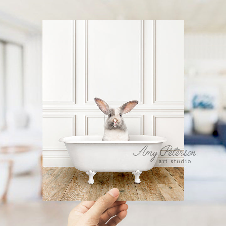 a person holding up a photo of a rabbit in a bathtub