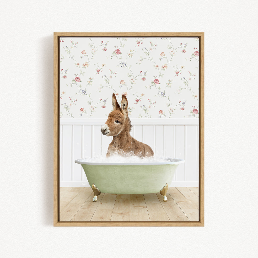 A donkey is sitting in a green bathtub filled with bubbles, with a floral wallpaper in the background.