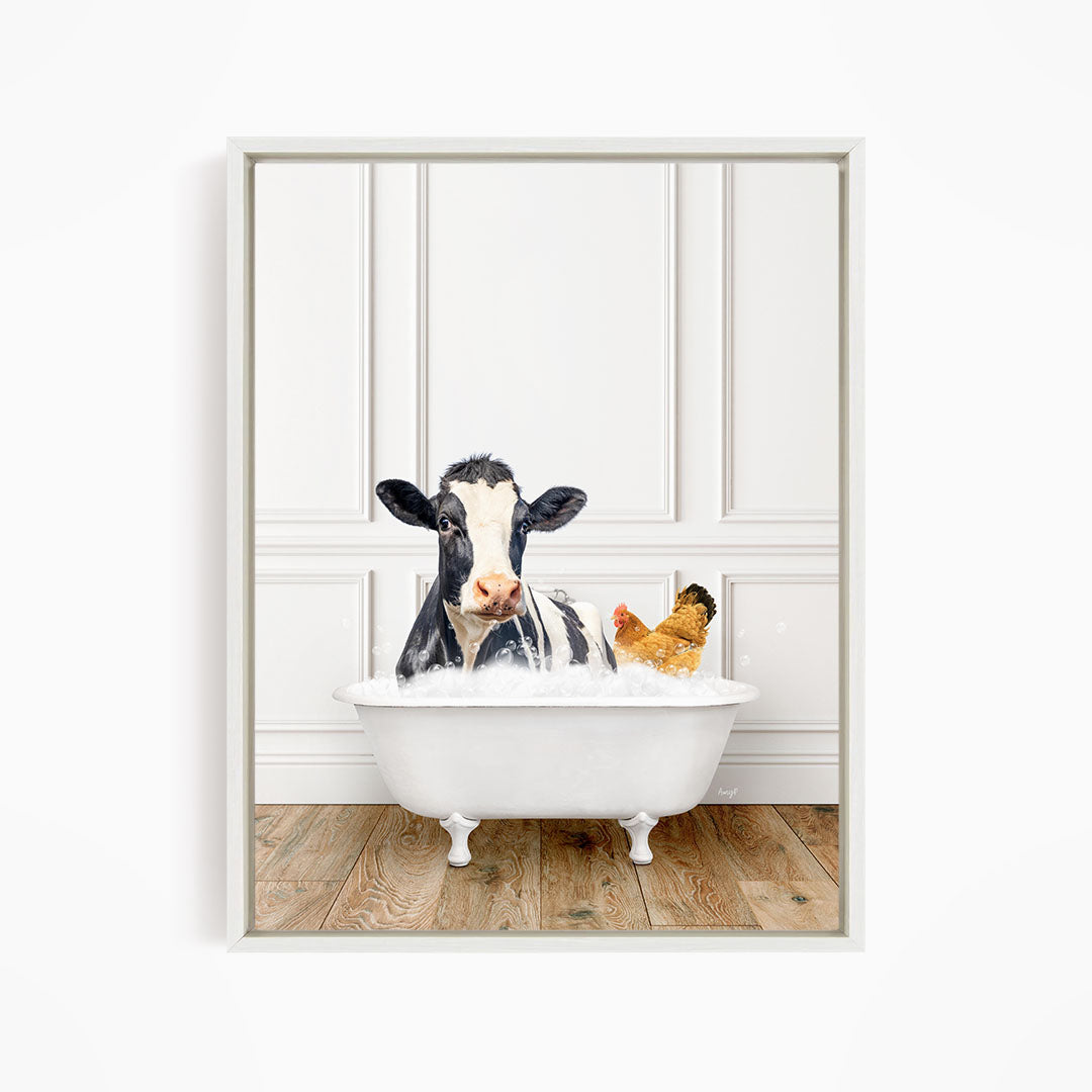 A black and white cow is sitting in a white bathtub, with a chicken nearby, in a white-walled room.