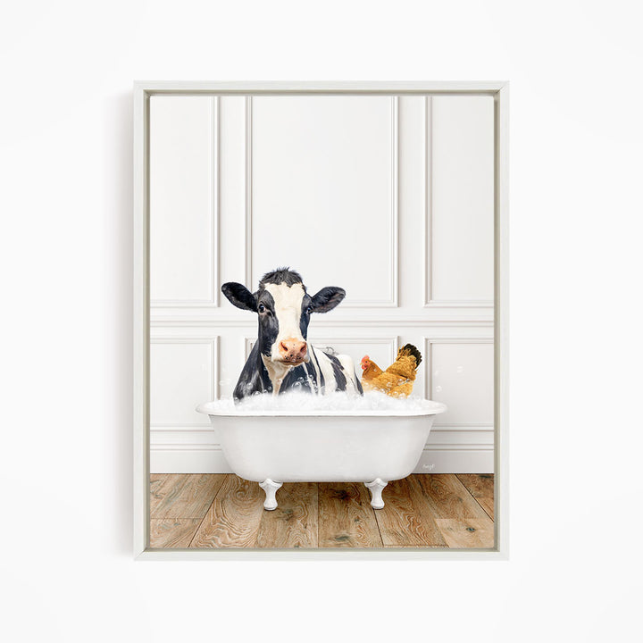 A black and white cow is sitting in a white bathtub, with a chicken nearby, in a white-walled room.