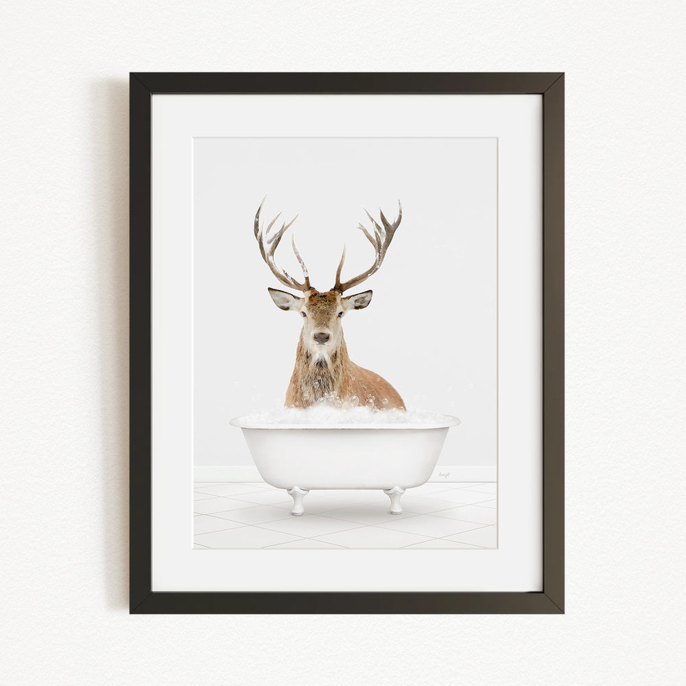 A deer with large antlers is sitting in a white bathtub filled with bubbles, creating a whimsical and humorous scene.