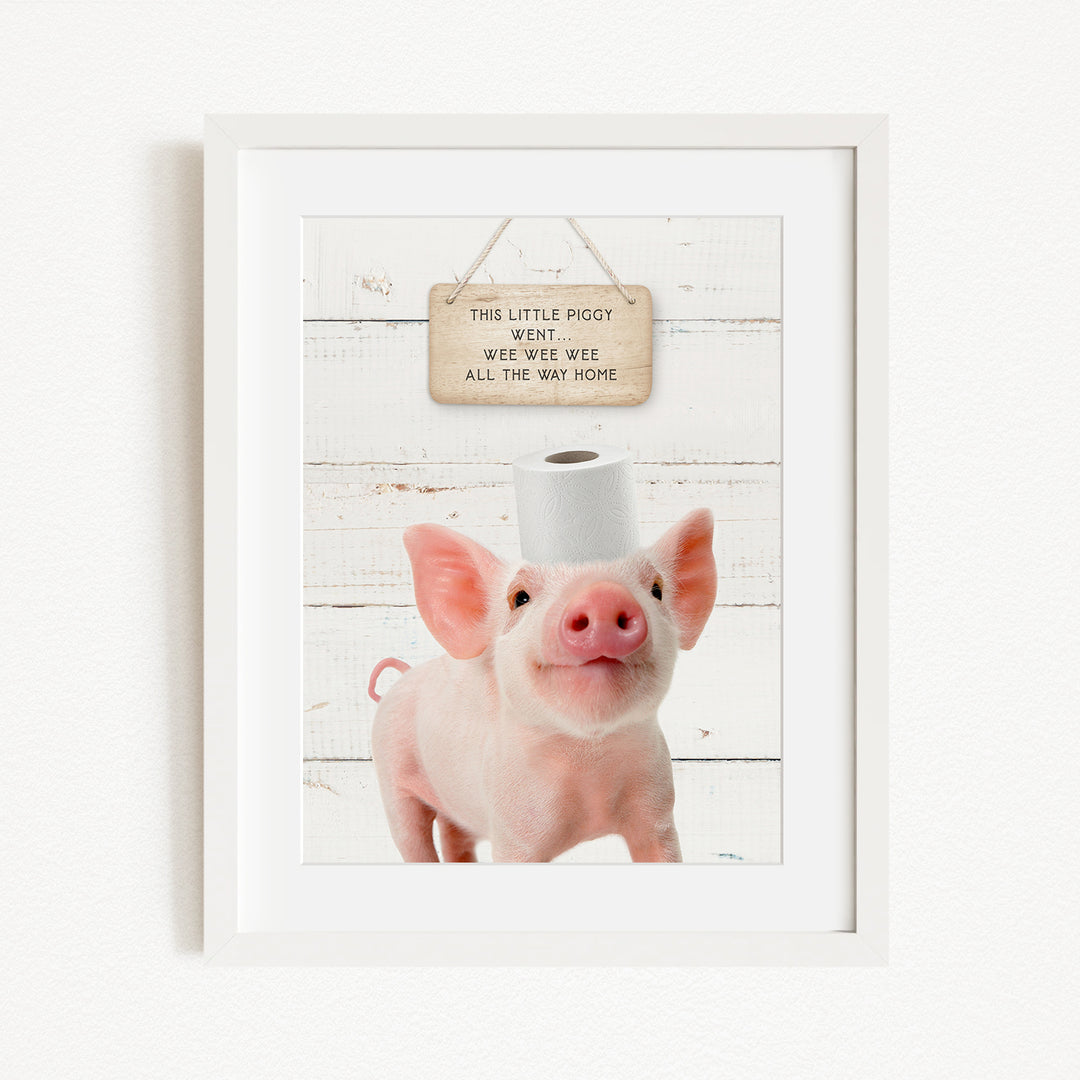 A framed image of a pig with a sign above it that reads "This little pig went weee weee all the way home".