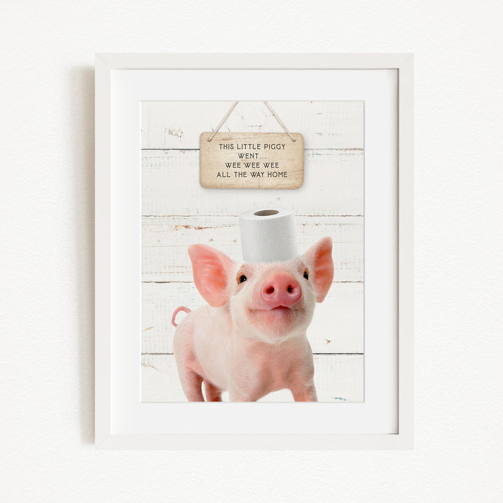 A framed image of a pig with a sign above it that reads "This little pig went weee weee all the way home".