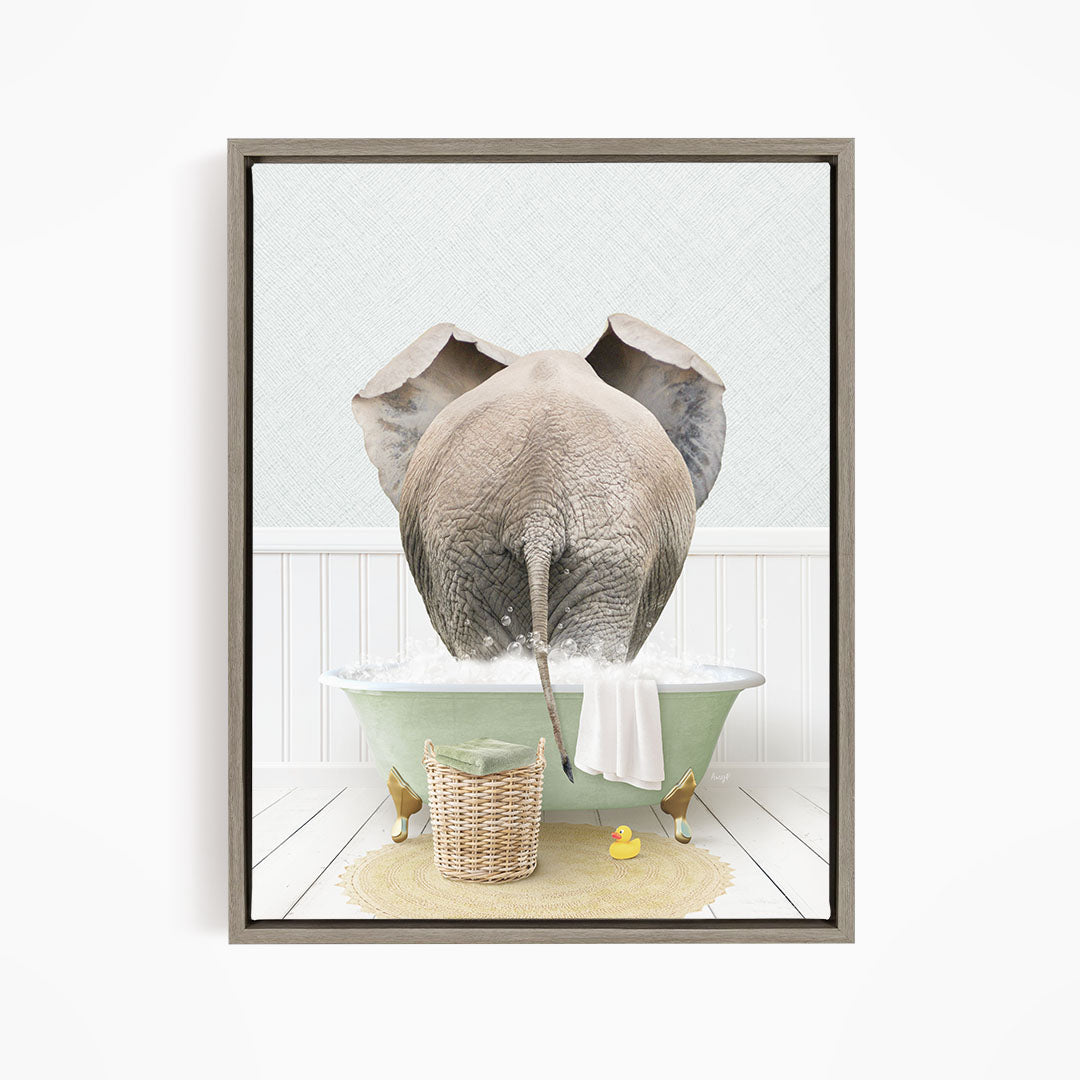 A gray elephant is standing in a green bathtub filled with water, surrounded by a basket of toys and a yellow rubber ducky.