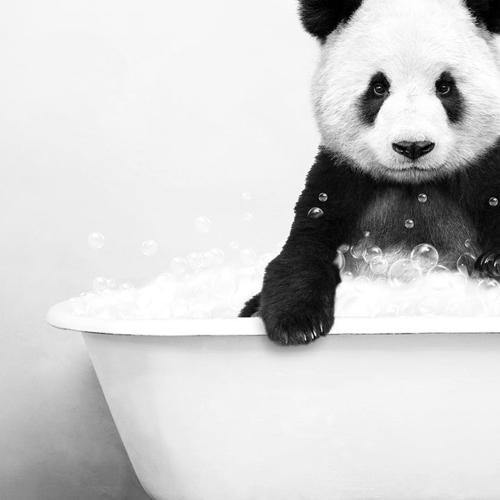 a black and white photo of a panda bear in a bathtub