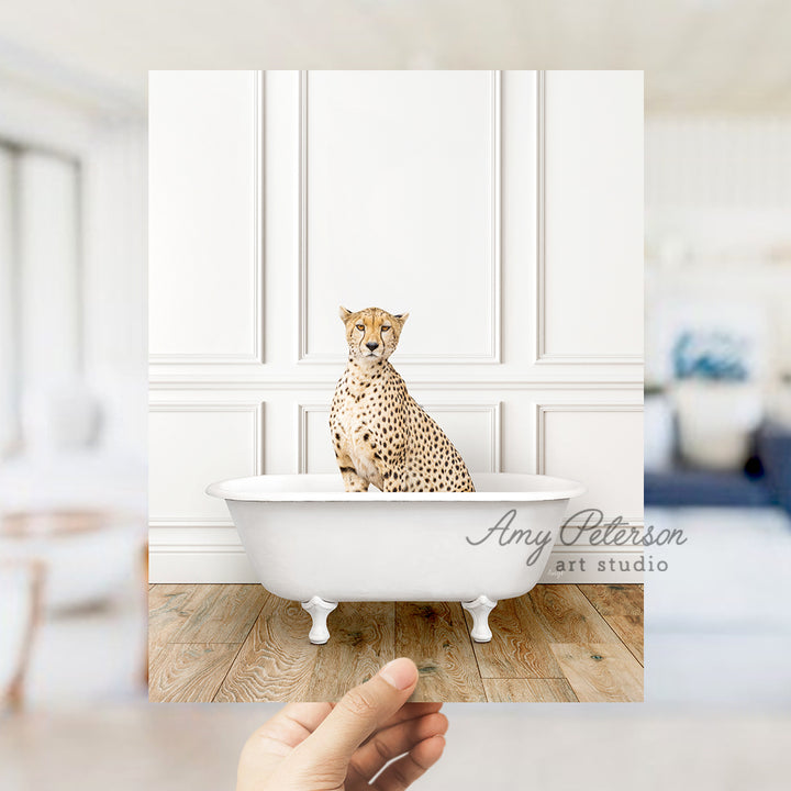 a hand holding a photo of a cheetah sitting in a bathtub