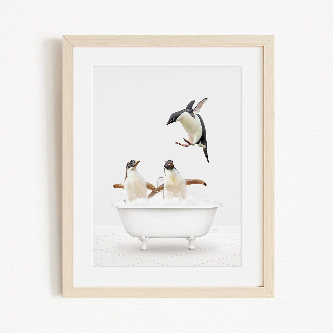A framed image depicting two penguins sitting in a bathtub, with one penguin flying towards the other penguin.