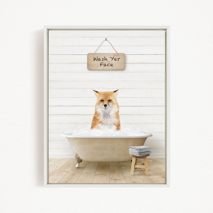 A red fox is sitting in a bathtub filled with water, with a sign above it that says "Wash Yer Face".