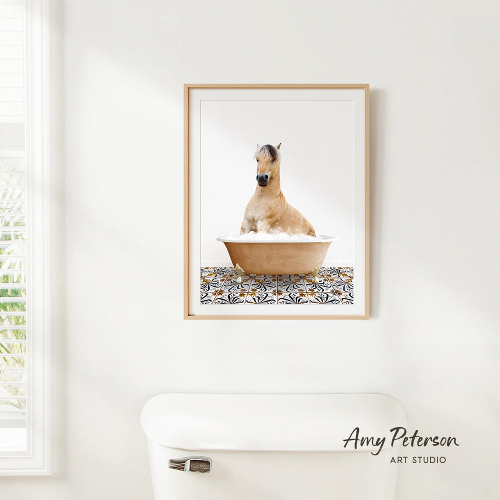 A framed image of a horse sitting in a bathtub, with a patterned tile on the floor.