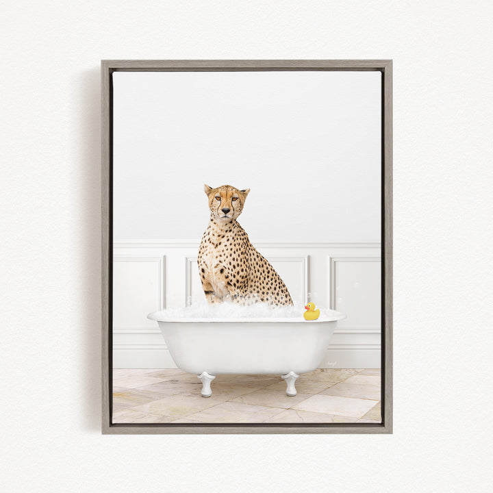 A cheetah sitting in a white bathtub filled with water, with a rubber duck floating in the water.