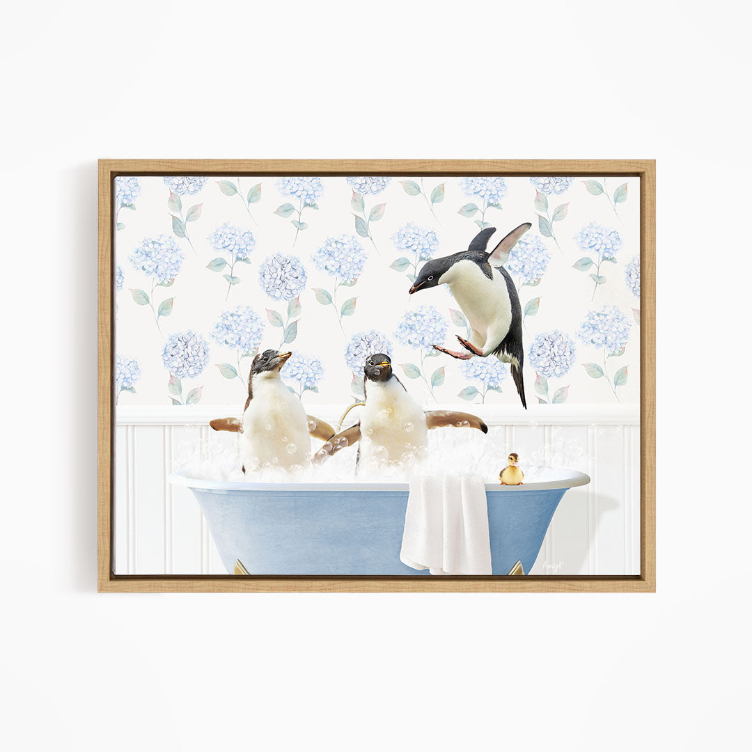 A framed image depicting three penguins sitting in a blue bathtub, with one penguin flying towards the tub.