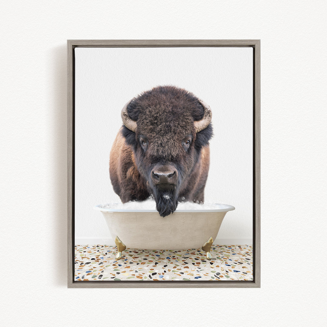 A buffalo with a long beard is standing in a white bathtub, looking directly at the camera.