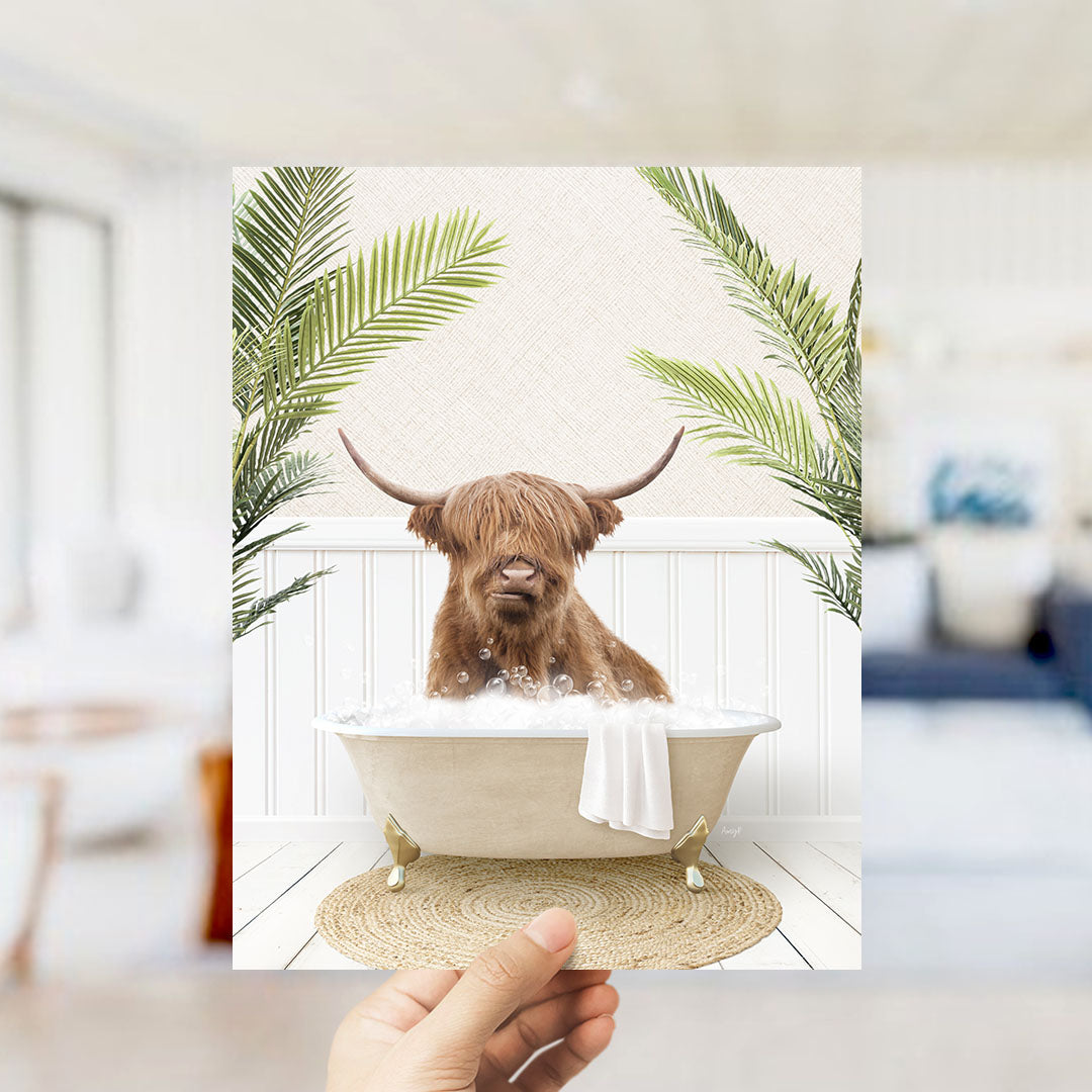 A brown cow with long horns is sitting in a bathtub filled with bubbles, surrounded by green palm leaves.