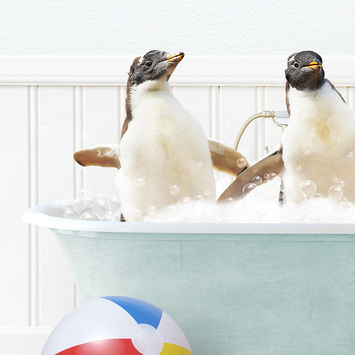 two penguins in a bathtub with bubbles and a beach ball