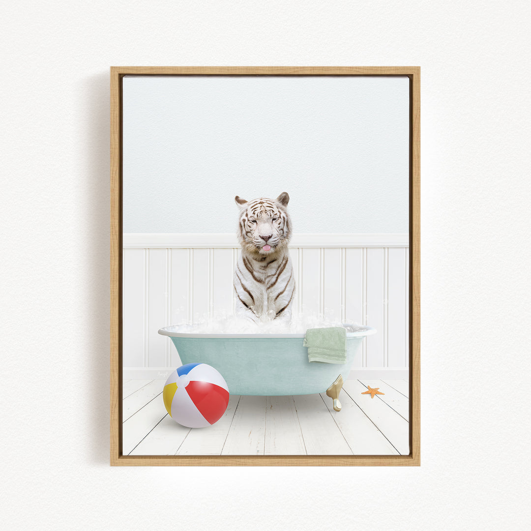 A white tiger is sitting in a bathtub filled with water, surrounded by a beach ball and a towel.