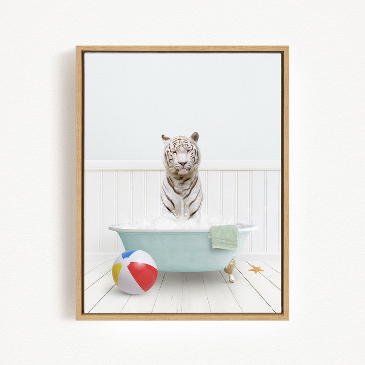 A white tiger is sitting in a bathtub filled with water, surrounded by a beach ball and a towel.