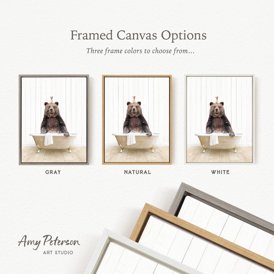 The image is a framed canvas option showcasing three different frame colors: gray, natural, and white. The canvas features a bear sitting in a bathtub, and the frame color options are displayed below the canvas.