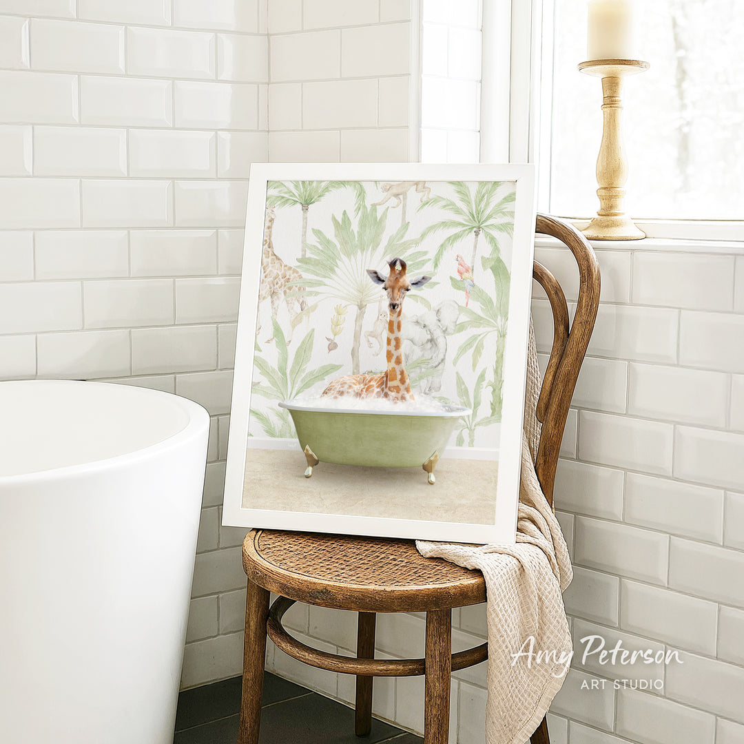 A framed image of a giraffe sitting in a bathtub, surrounded by tropical foliage, is displayed on a wooden chair in a bathroom setting.