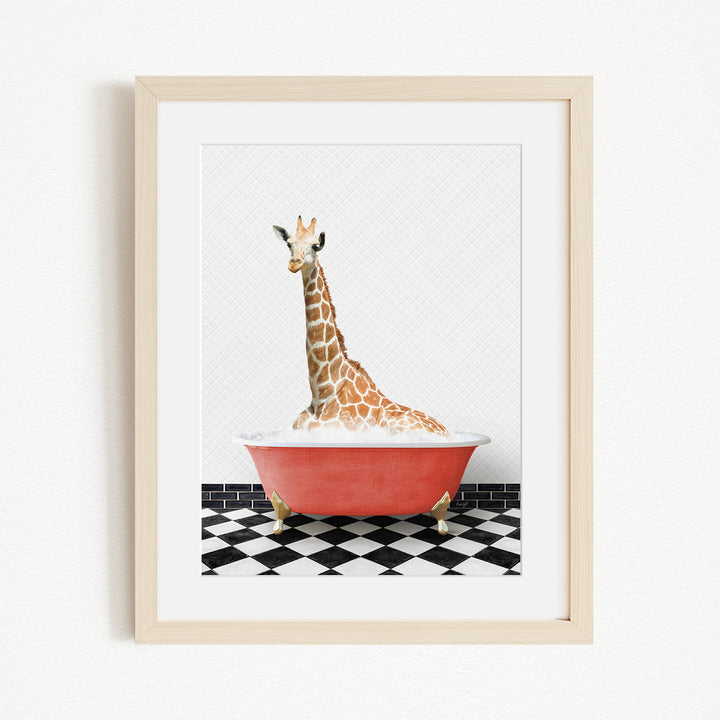 A giraffe is sitting in a red bathtub on a black and white checkered floor.