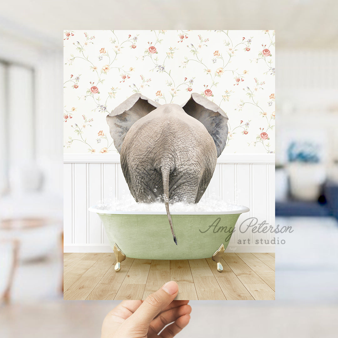 a hand holding up a picture of an elephant in a bathtub