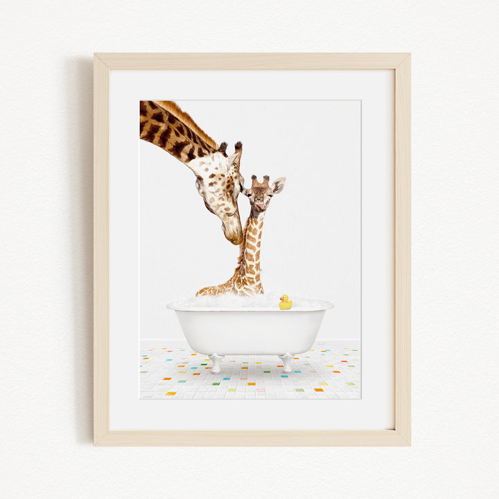 A giraffe and a baby giraffe are sitting in a white bathtub filled with bubbles, with a yellow rubber duck floating in the water.