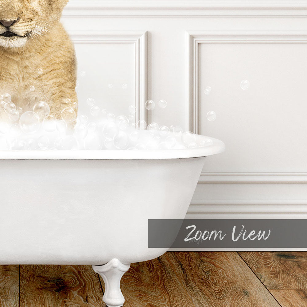 A cat sitting in a white bathtub filled with bubbles, with a wooden floor visible in the background.