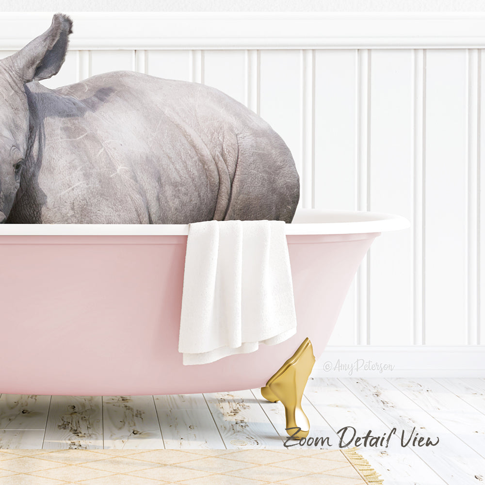 A rhinoceros is sitting in a pink bathtub, with a white towel hanging on the side and a gold shoe placed on the floor next to the tub.