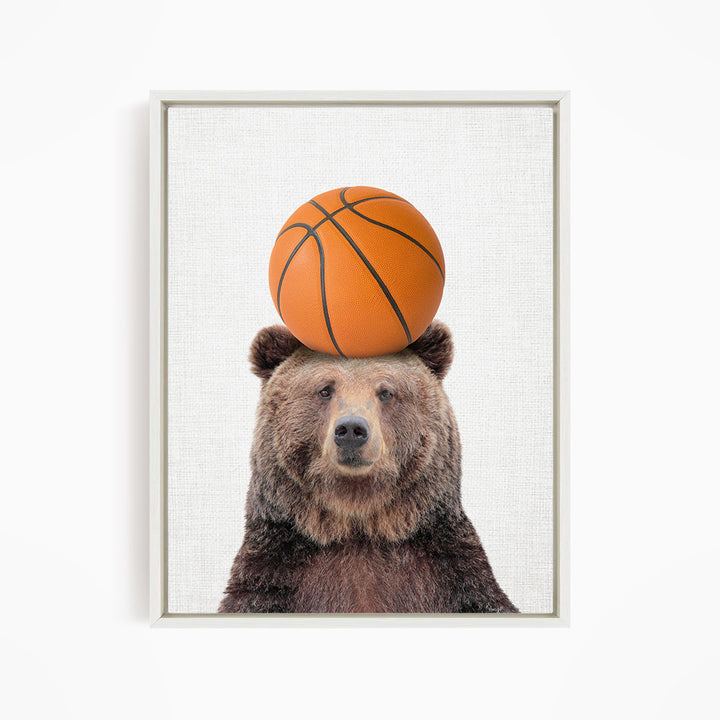 A brown bear balancing a basketball on its head.