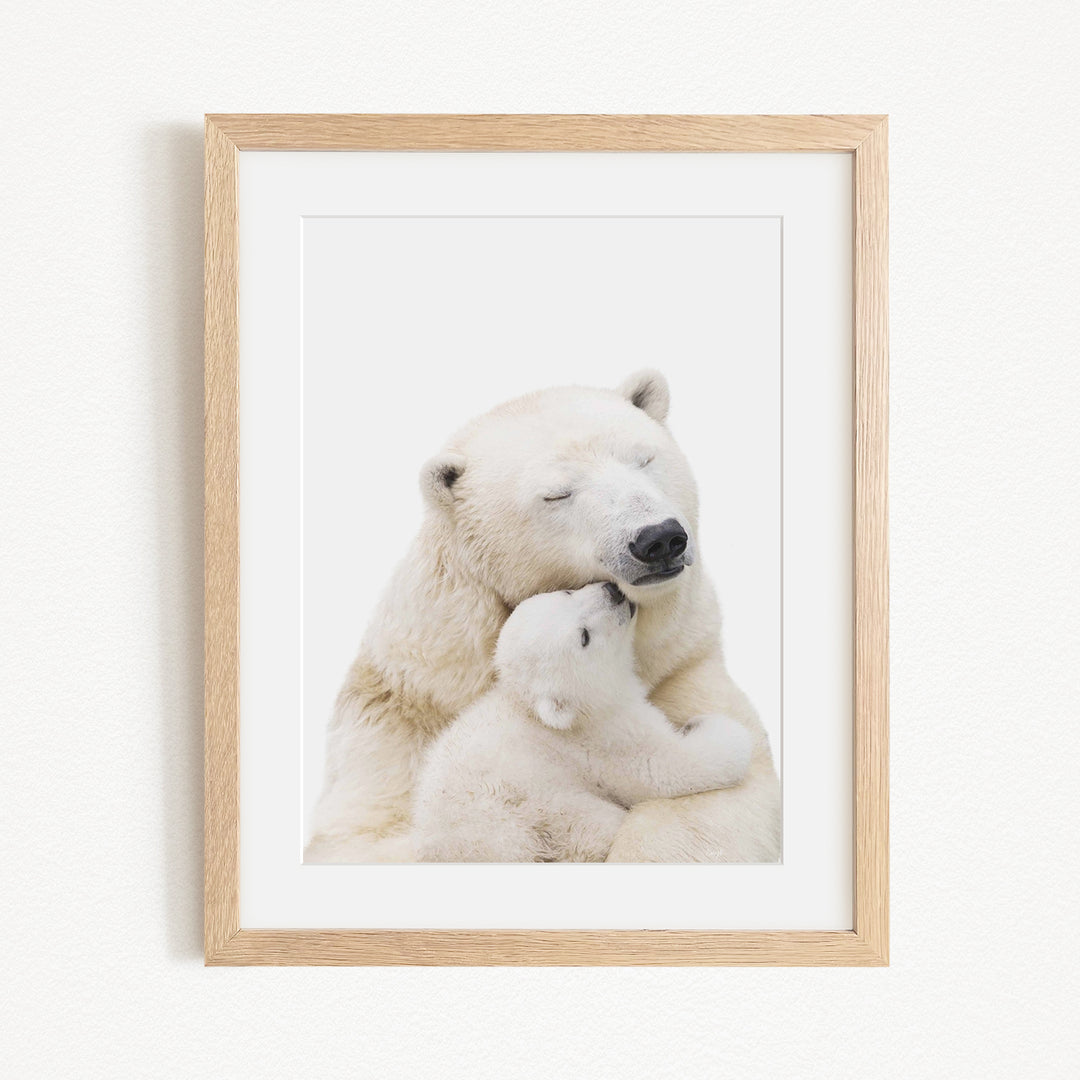 A mother polar bear tenderly embracing her cub in a serene, snowy landscape.