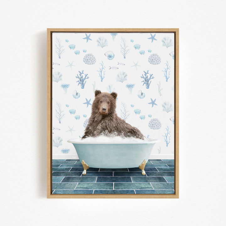 A brown bear sitting in a bathtub filled with bubbles, surrounded by a blue and white ocean-themed wallpaper.