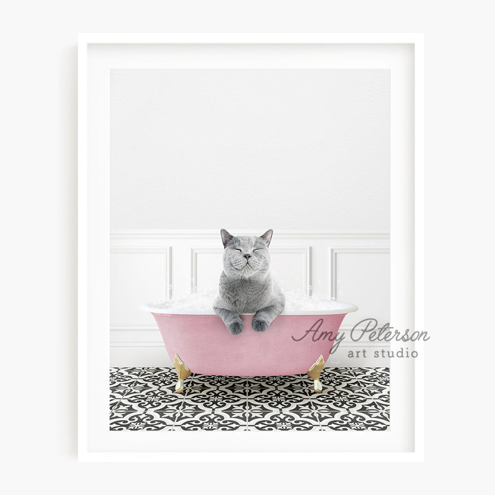 a gray cat sitting in a pink bath tub