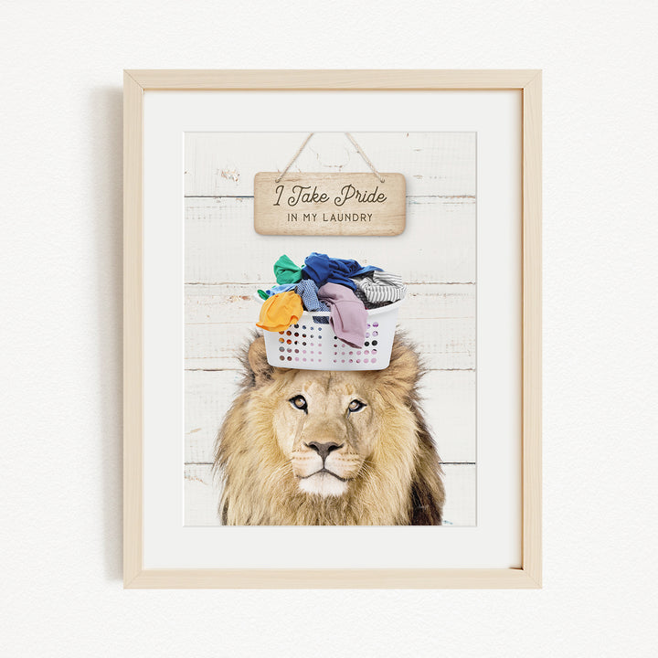 A framed image of a lion wearing a basket of laundry, with a sign above that says "I take pride in my laundry".