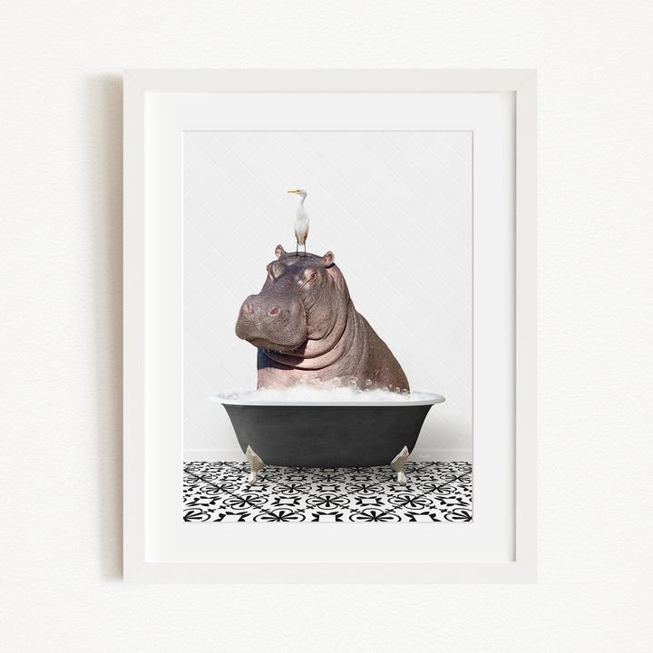 A framed image depicting a large hippopotamus sitting in a bathtub, with a seagull perched on its head.