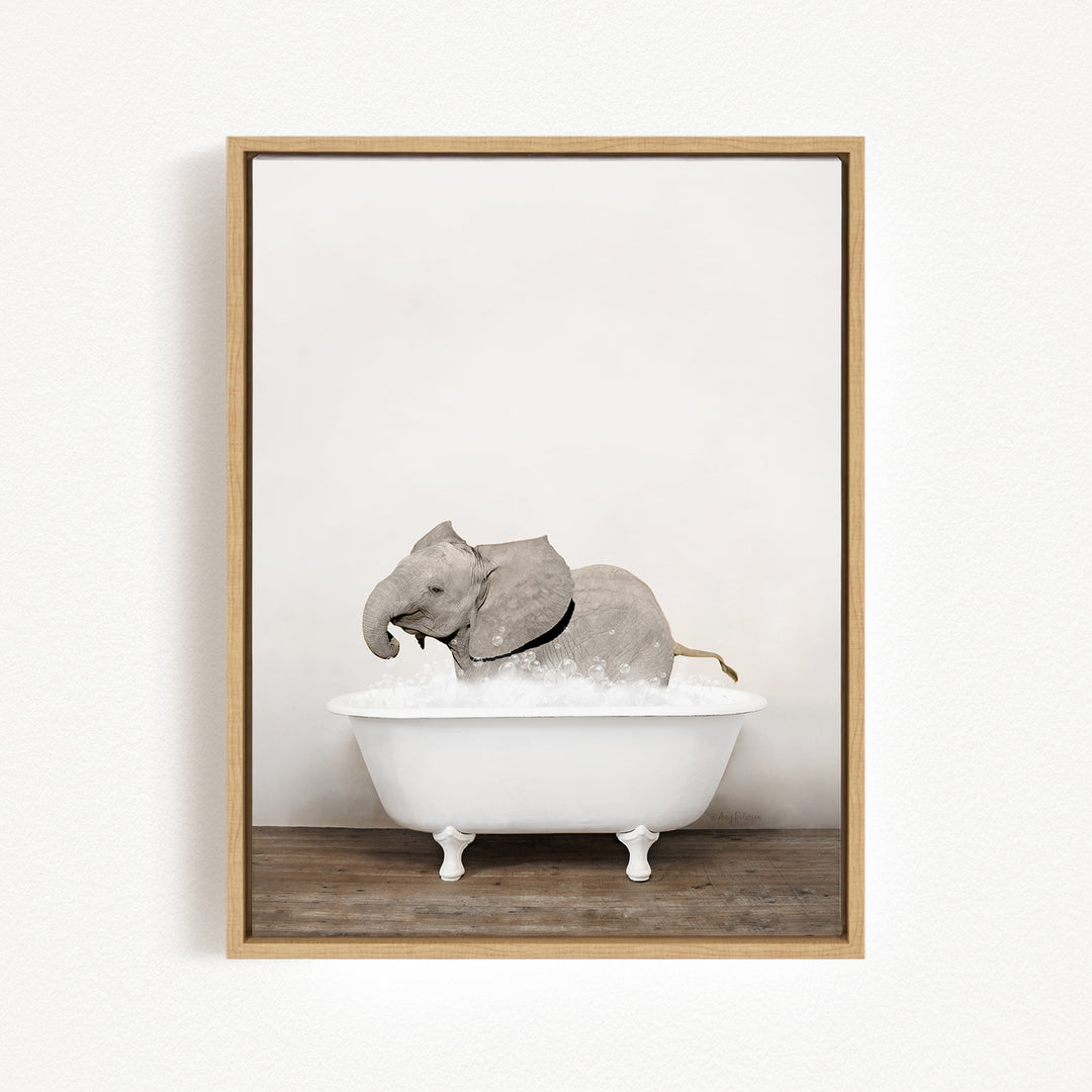 A gray elephant is sitting in a white bathtub, enjoying a bath.