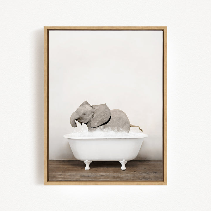 A gray elephant is sitting in a white bathtub, enjoying a bath.