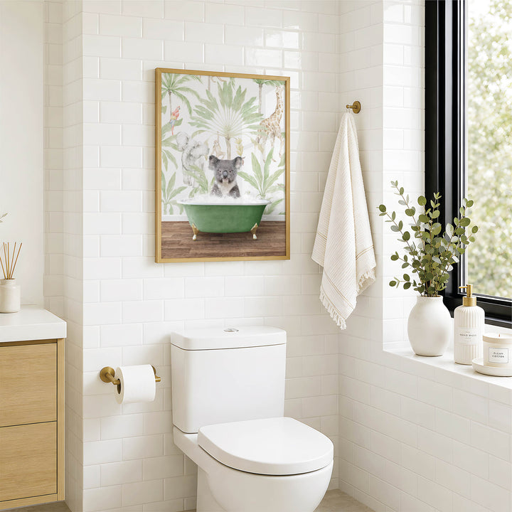 A bathroom with a white toilet, a framed picture of a koala sitting in a bathtub, and a window with greenery outside.