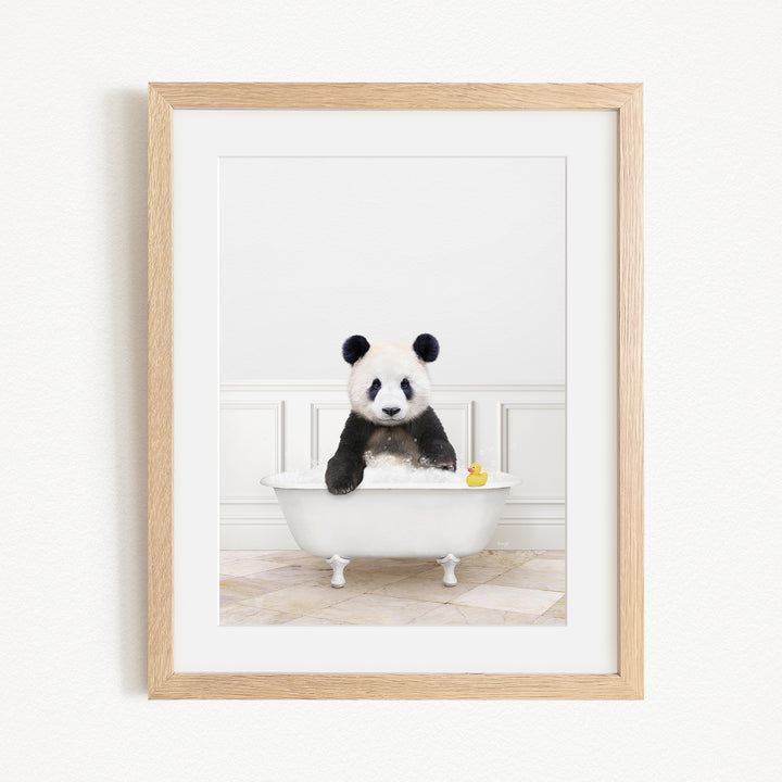 A panda bear sitting in a white bathtub, surrounded by a yellow rubber duck.