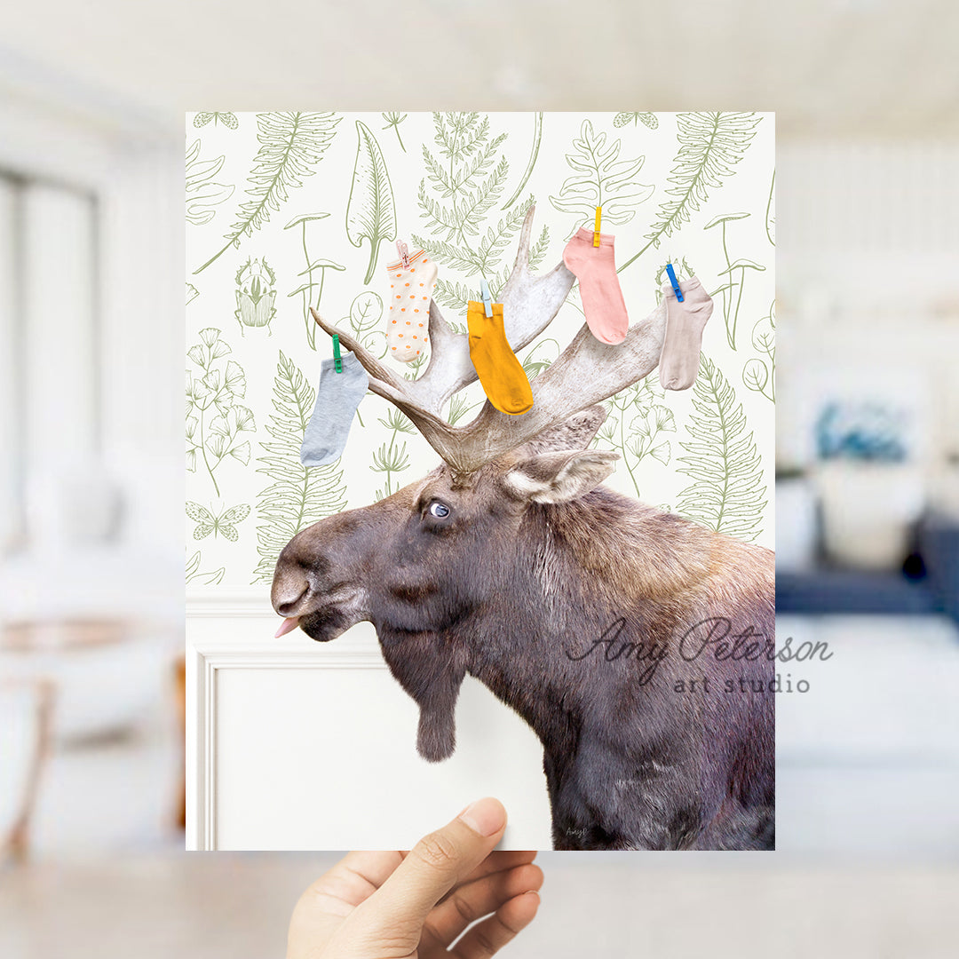 a hand holding up a card with a picture of a moose