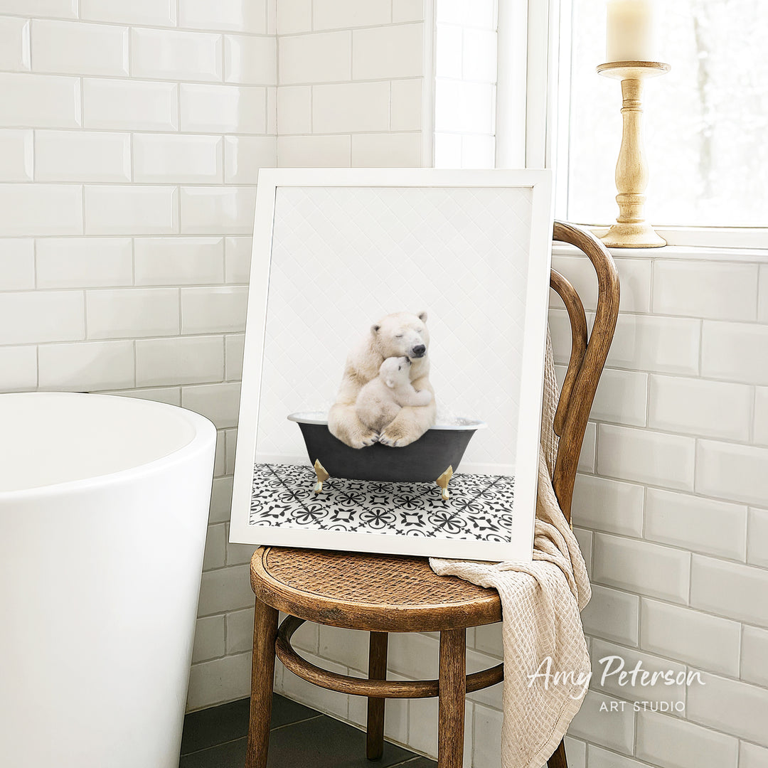 A framed image of two polar bears sitting in a bathtub is displayed on a wooden chair in a bathroom setting.