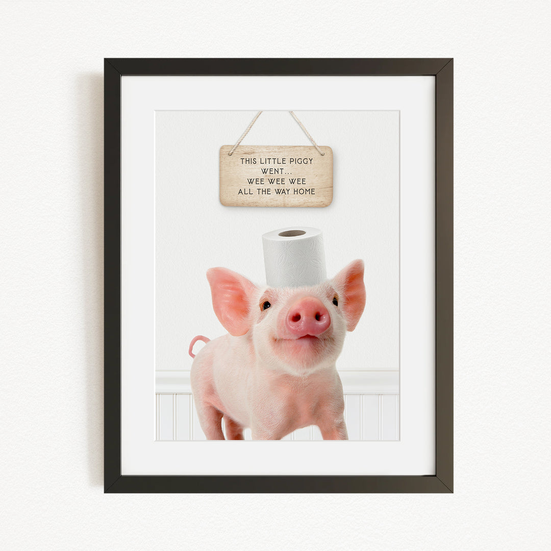 A framed image of a pig wearing a toilet paper roll on its head, with a sign above it that reads "This little piggy went wite wate wate all the way home".