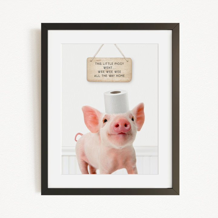A framed image of a pig wearing a toilet paper roll on its head, with a sign above it that reads "This little piggy went wite wate wate all the way home".